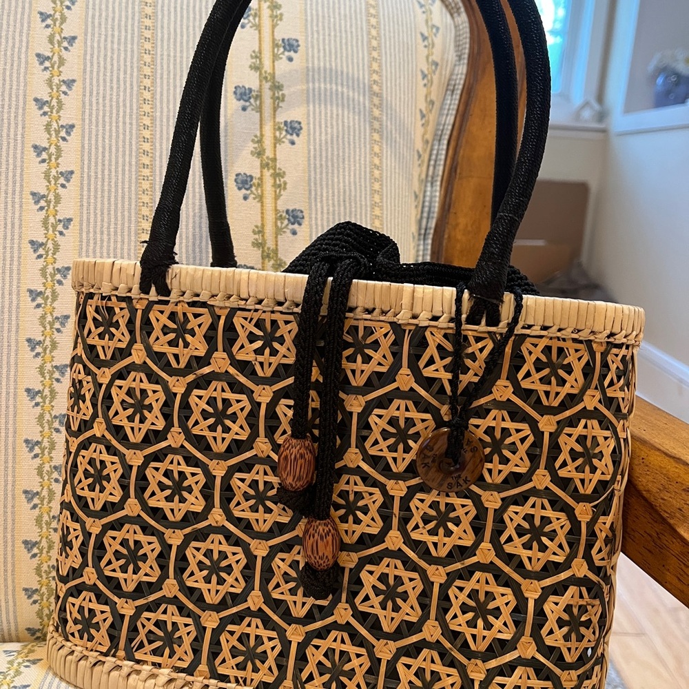 The Sak Black and Tan Straw Bag with Ornate Design Inner Drawstring Liner